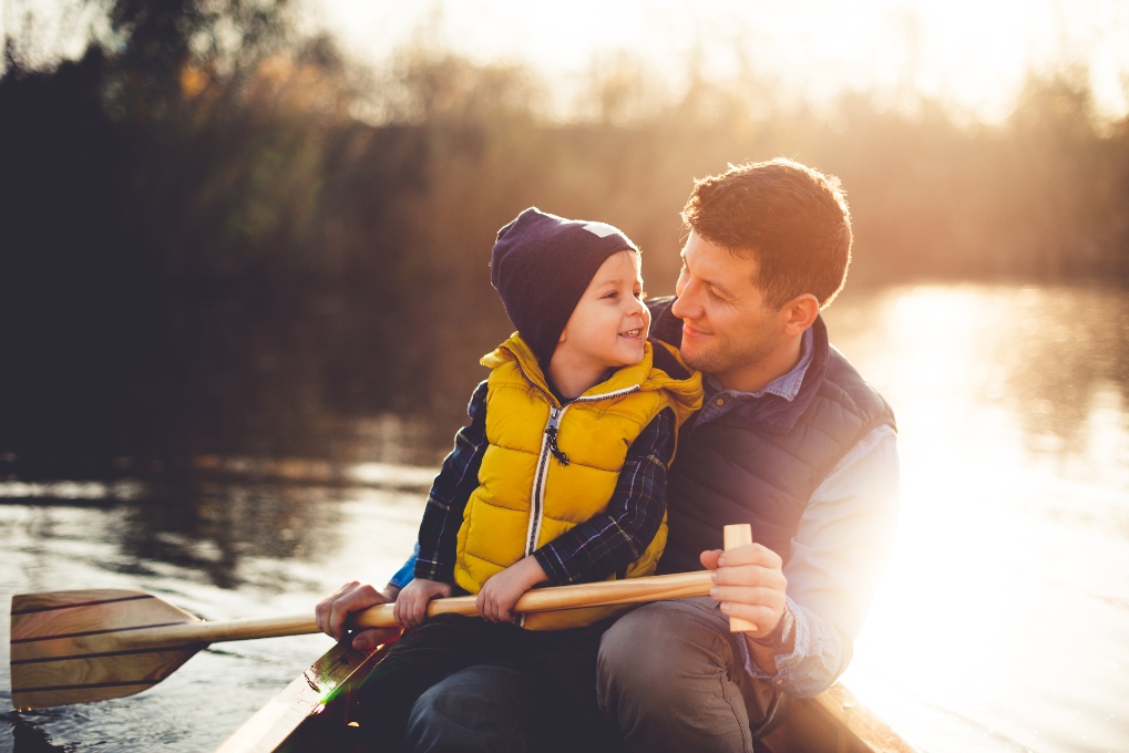 Father and son rowing a canoe together on a lake